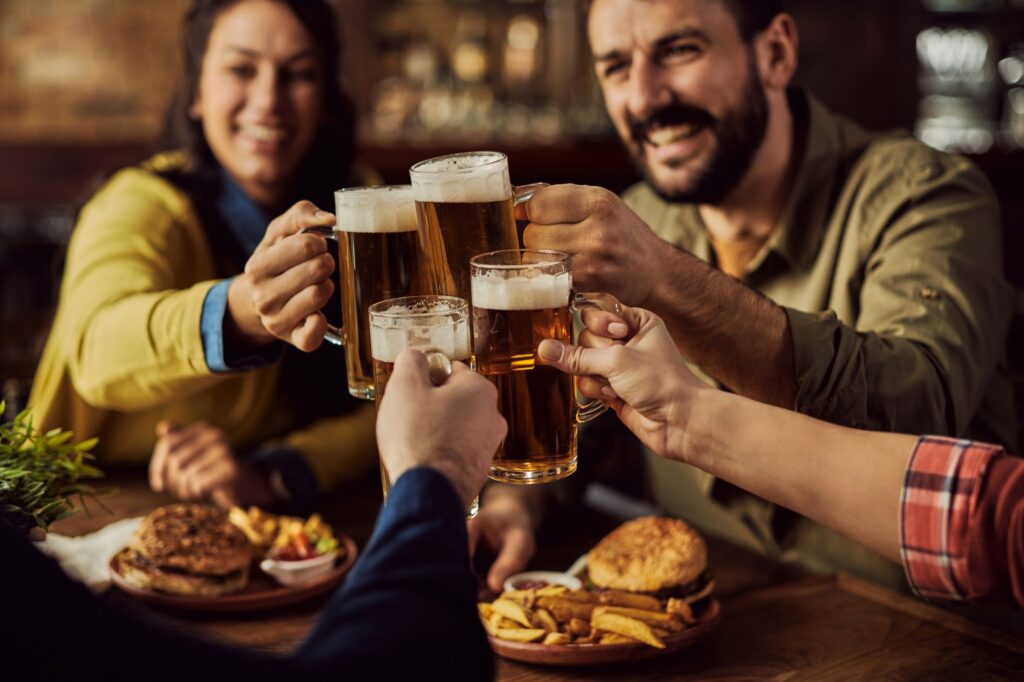 Close-up of friends toasting with beer in a pub.